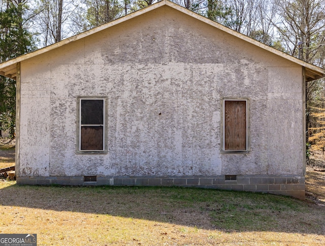 view of home's exterior with stucco siding, a lawn, and crawl space