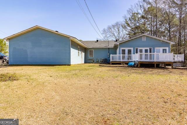 back of house featuring a deck and a lawn