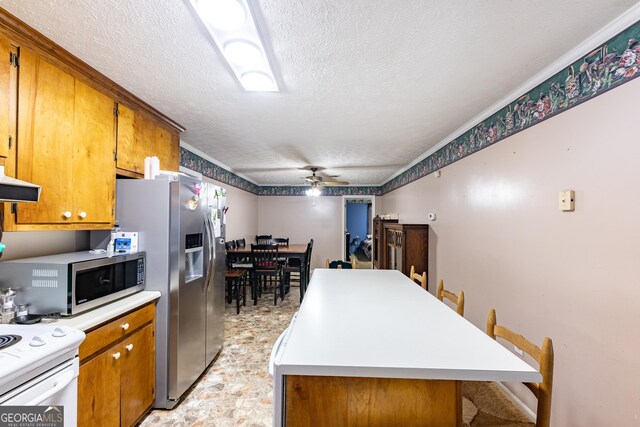 kitchen with exhaust hood, brown cabinets, appliances with stainless steel finishes, and a center island