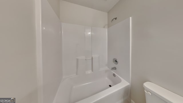 full bathroom featuring toilet and a textured ceiling
