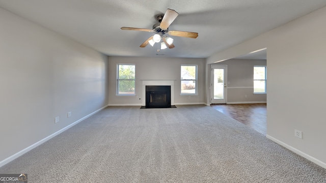unfurnished living room featuring baseboards, carpet, and ceiling fan