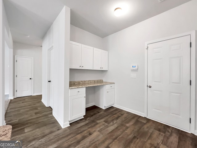 clothes washing area featuring baseboards and dark wood-style flooring