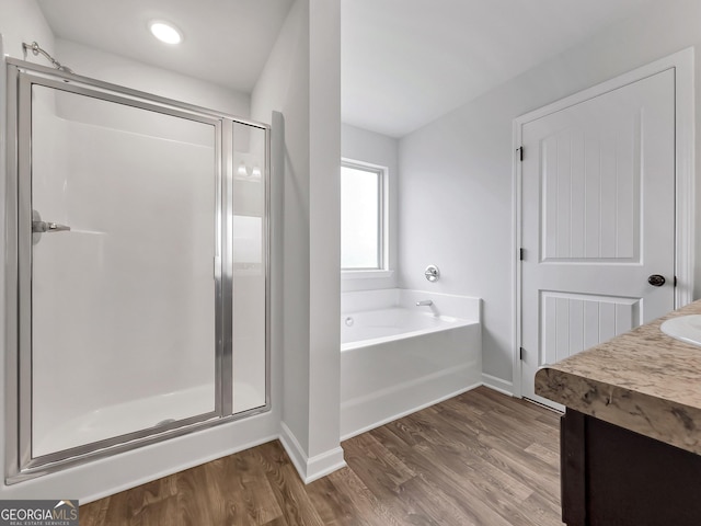 full bathroom with vanity, wood finished floors, baseboards, a shower stall, and a bath