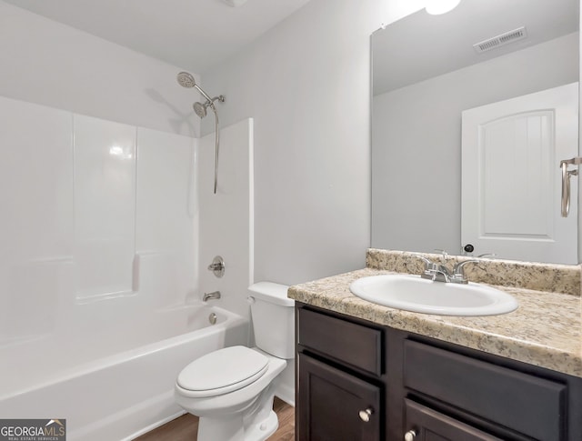 full bathroom featuring vanity, wood finished floors, visible vents, shower / bathing tub combination, and toilet