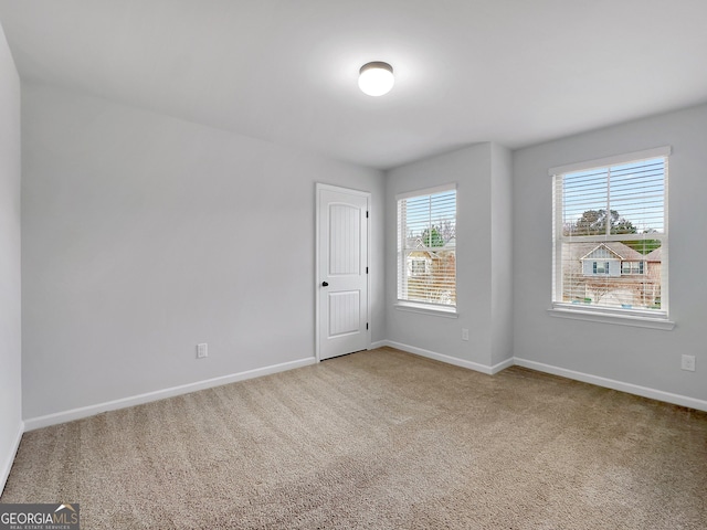 spare room featuring baseboards and carpet flooring