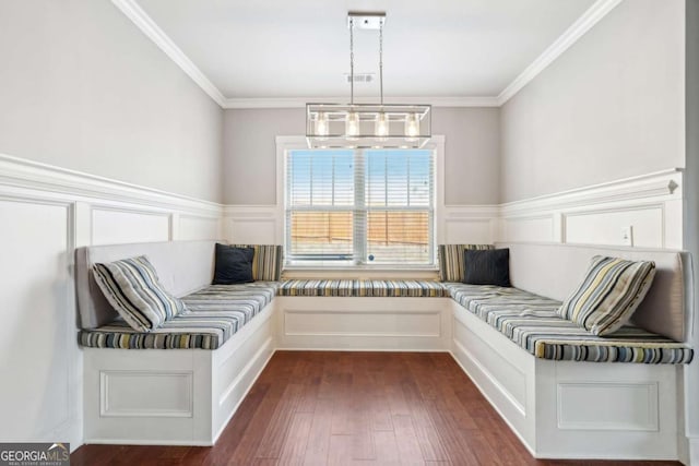unfurnished room with a decorative wall, dark wood-style flooring, a chandelier, and ornamental molding