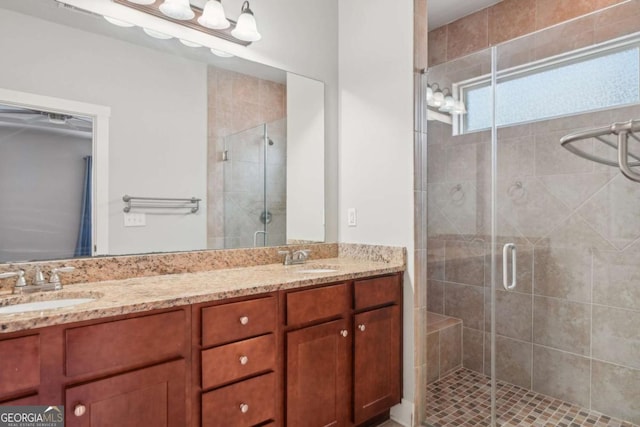 full bath featuring a sink, a stall shower, and double vanity