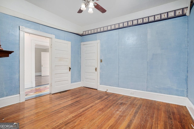 spare room with wood finished floors and ceiling fan