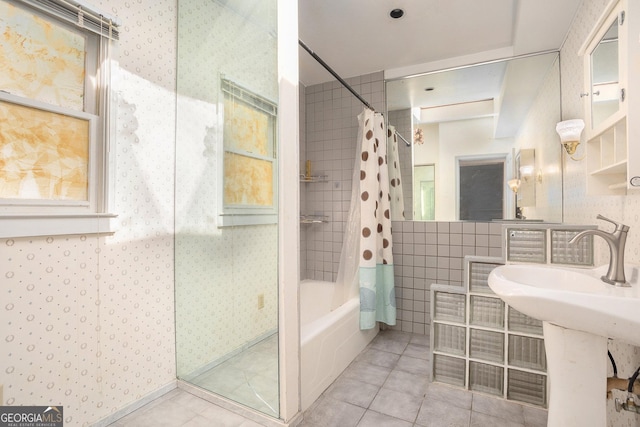 bathroom featuring wallpapered walls, tile patterned floors, tile walls, and shower / bath combo