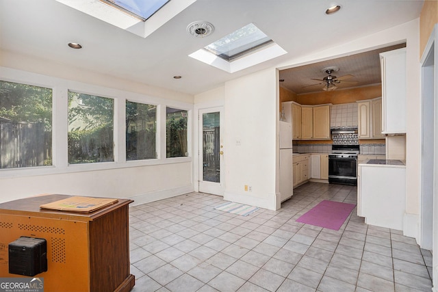 kitchen with backsplash, light countertops, range with gas stovetop, recessed lighting, and light tile patterned flooring