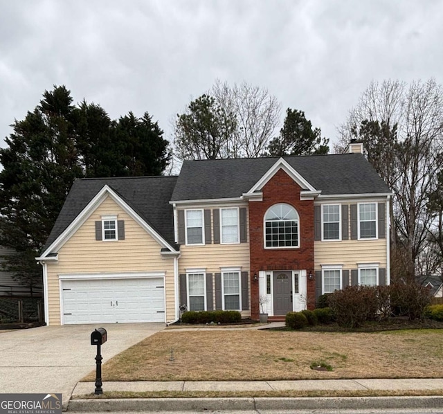 view of front facade with a chimney, an attached garage, concrete driveway, and a front yard