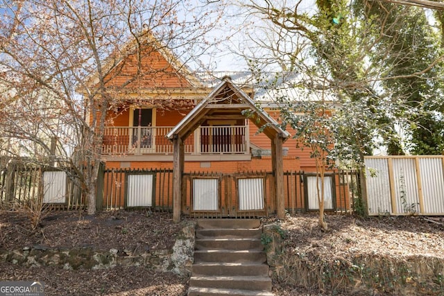 view of front facade featuring a balcony and fence