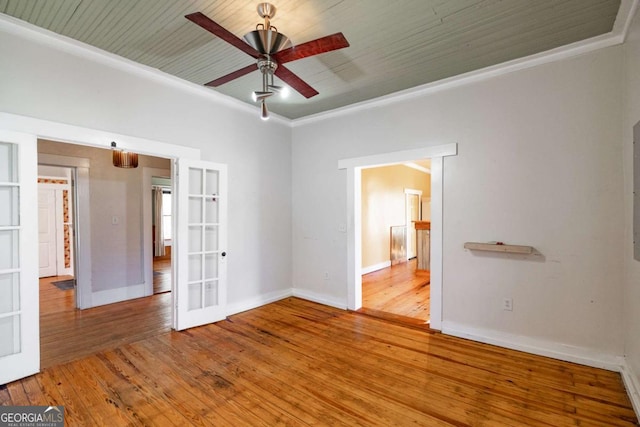 spare room featuring baseboards, ornamental molding, ceiling fan, french doors, and wood-type flooring