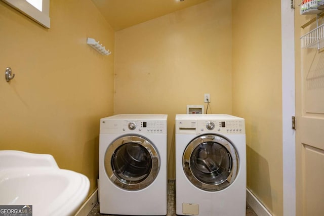 laundry room with washer and dryer and a sink