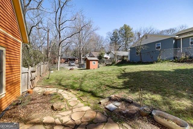 view of yard featuring an outbuilding, a shed, and a fenced backyard