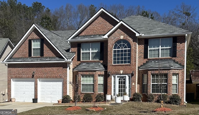 traditional-style house featuring a garage, brick siding, and concrete driveway