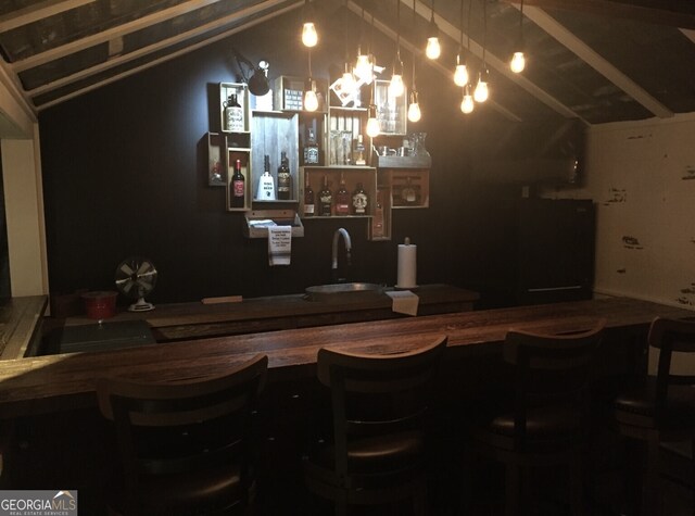 indoor wet bar featuring vaulted ceiling