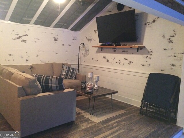 living area with wood finished floors and lofted ceiling