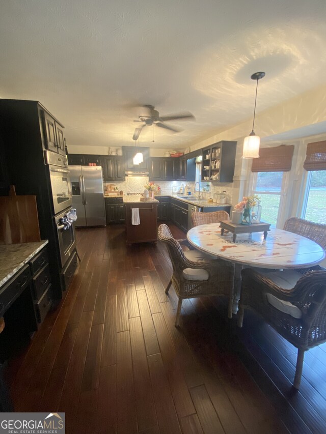dining space with dark wood finished floors and ceiling fan