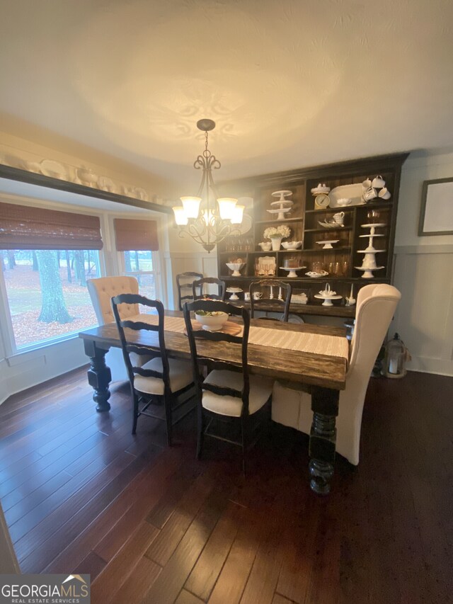 dining space featuring wood-type flooring and a chandelier