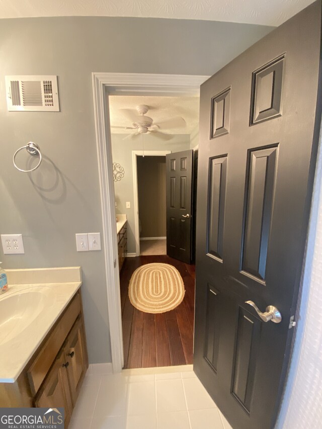 bathroom with vanity, baseboards, tile patterned floors, and a ceiling fan