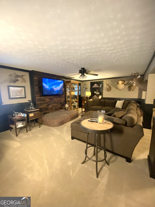 living room with carpet, a textured ceiling, wood walls, and ceiling fan