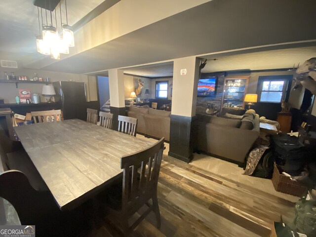 dining area with wood finished floors and a chandelier