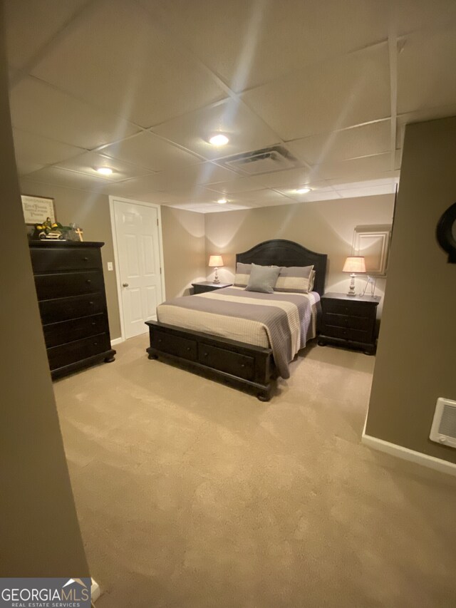 bedroom with carpet, a paneled ceiling, and baseboards