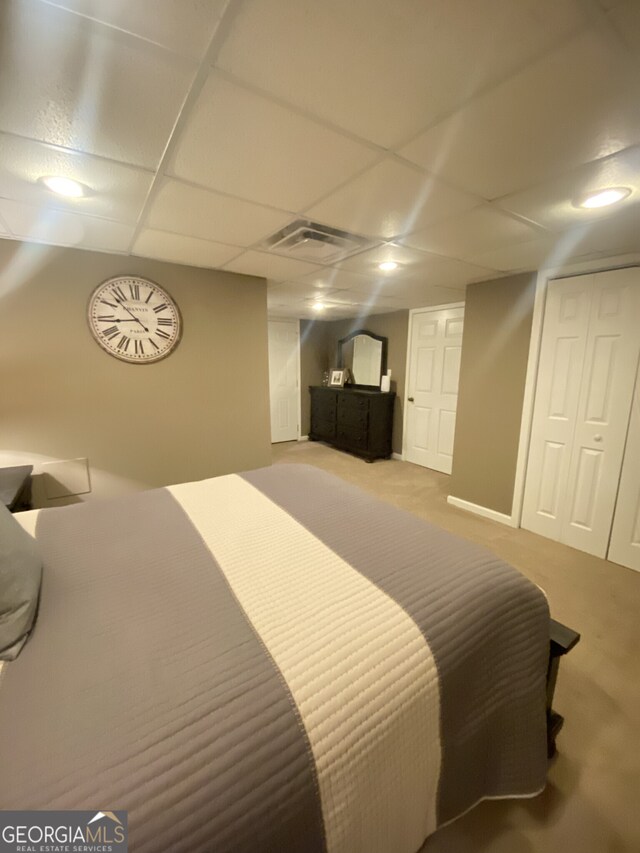 carpeted bedroom with a drop ceiling