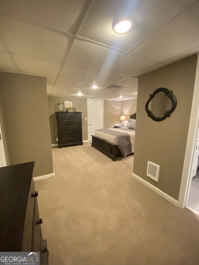 bedroom with carpet floors, baseboards, and a drop ceiling
