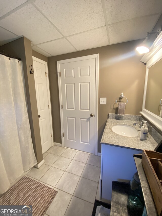 full bath with a drop ceiling, tile patterned flooring, vanity, and a shower with shower curtain
