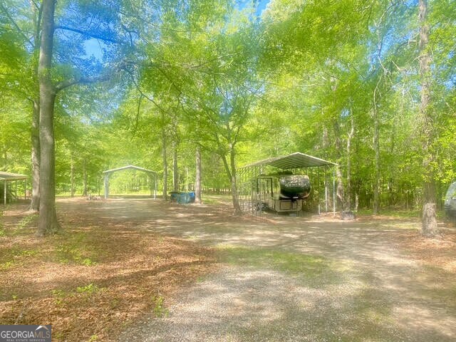 view of home's community featuring a detached carport and dirt driveway