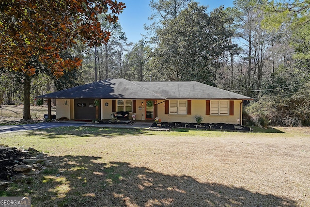 view of front of property with driveway, a front yard, and an attached garage