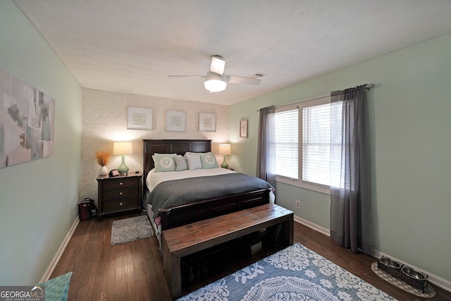 bedroom with ceiling fan, visible vents, baseboards, and wood finished floors