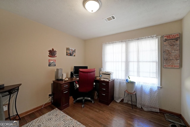 office area with visible vents, baseboards, a textured ceiling, and wood finished floors