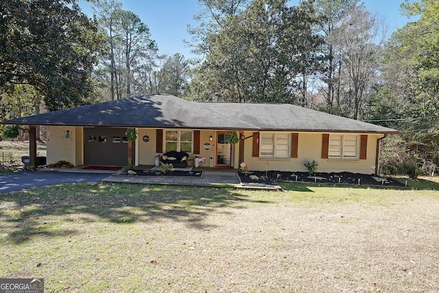 ranch-style home with brick siding, a front lawn, aphalt driveway, covered porch, and a garage