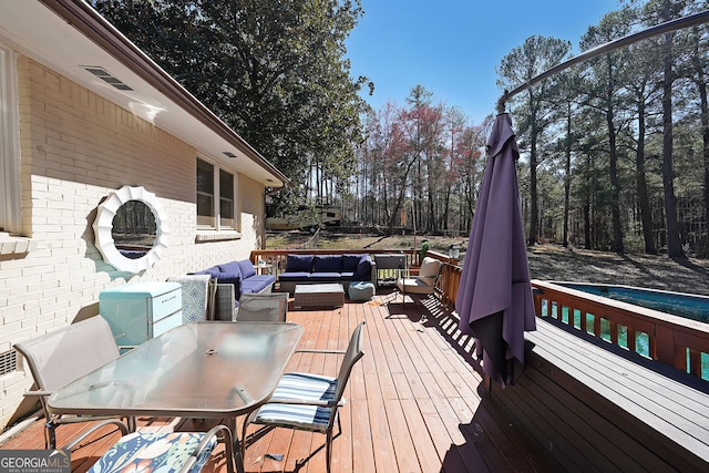 wooden terrace featuring outdoor dining space and outdoor lounge area