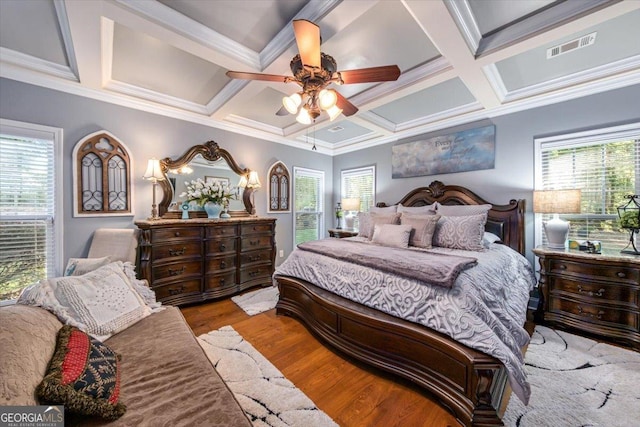 bedroom with visible vents, coffered ceiling, wood finished floors, crown molding, and ceiling fan