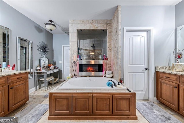 full bath with vanity, a bath, a fireplace, and a tile shower