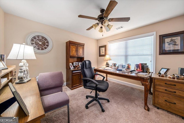 home office featuring ceiling fan, light colored carpet, visible vents, and baseboards