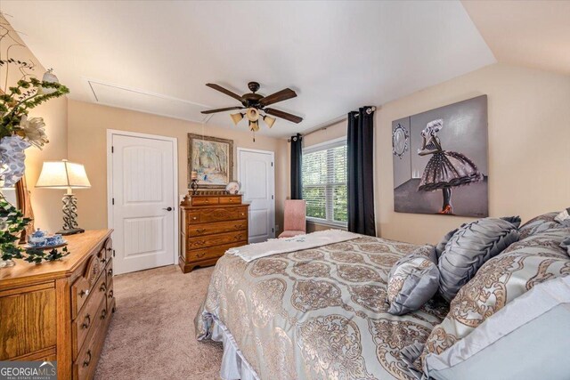 bedroom with ceiling fan, lofted ceiling, and light carpet