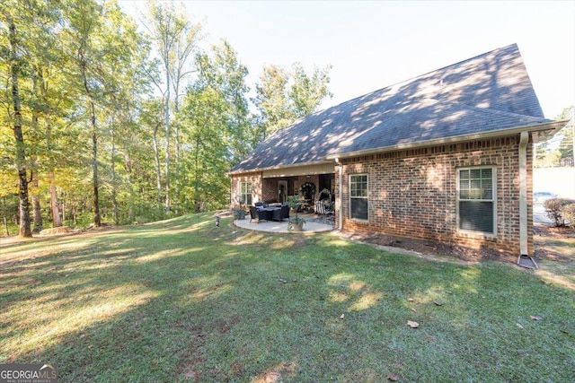 back of house with a patio, a lawn, brick siding, and a shingled roof