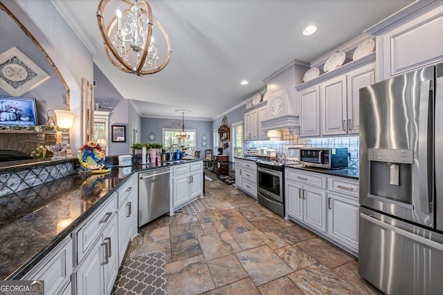 kitchen featuring an inviting chandelier, crown molding, tasteful backsplash, and stainless steel appliances