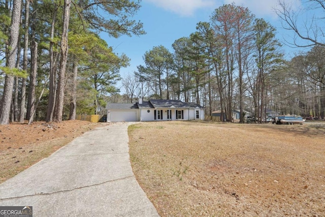 ranch-style home with a front yard, concrete driveway, and an attached garage