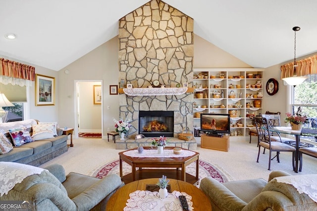 living area with baseboards, a stone fireplace, high vaulted ceiling, and carpet