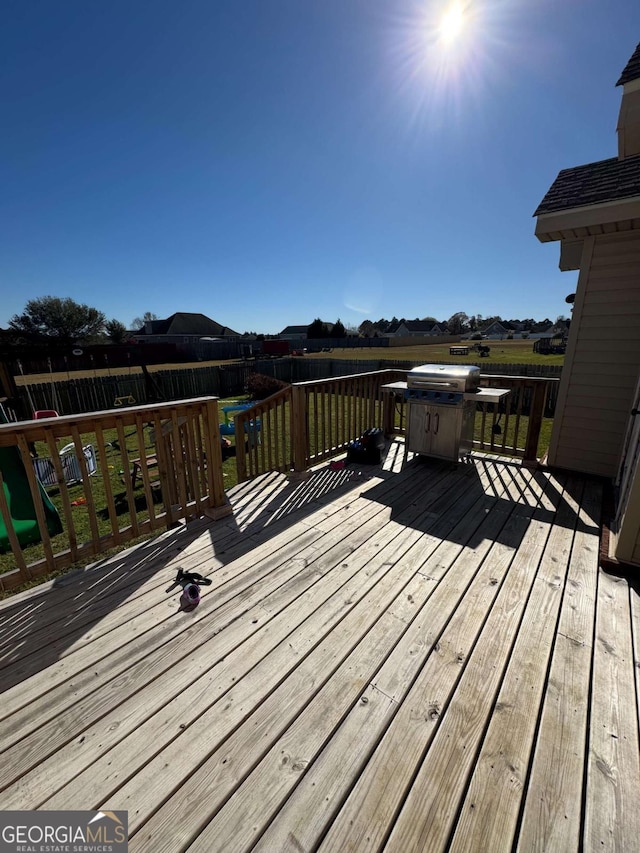 wooden terrace featuring grilling area and fence