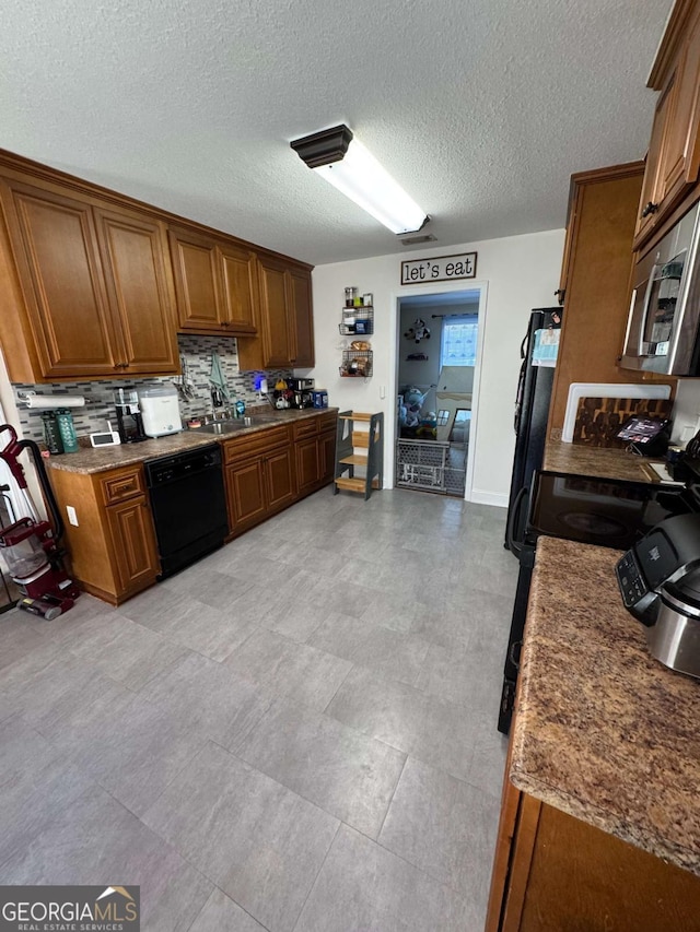 kitchen with brown cabinets, backsplash, black appliances, and a textured ceiling