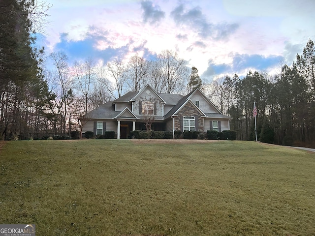 view of front of house with a front yard and stone siding