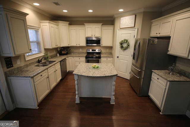 kitchen featuring light stone counters, visible vents, a sink, stainless steel appliances, and dark wood-type flooring