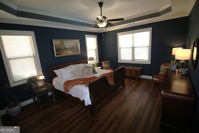 bedroom featuring a raised ceiling, crown molding, dark wood-style floors, and baseboards